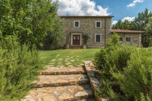 een stenen huis met een stenen loopbrug ervoor bij Exclusive Villa Parrano - countryside with pool in Parrano