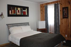 A bed or beds in a room at Auberge du sportif