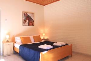 a bedroom with a bed with two towels on it at New Okella Hotel at Saittas in Saittas