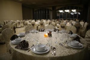 una mesa con vasos y platos en una habitación en Palestine Plaza Hotel, en Ramallah