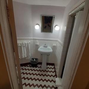 a bathroom with a white sink and a checkered floor at Historic Wigwam Village No 2 in Cave City