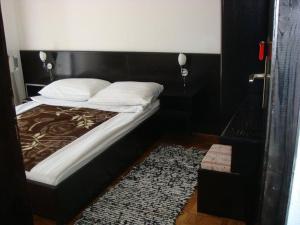 a bedroom with a bed with a black headboard at Guest house Dragović in Sveti Stefan