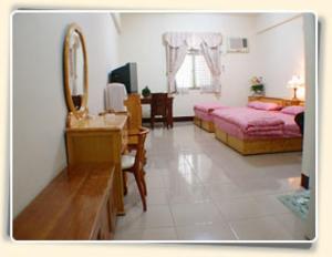 - une chambre avec un lit, un miroir et une commode dans l'établissement Dong Li Tea Homestay, à Ruisui