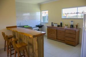 a kitchen with a counter and some chairs in it at Village Taipu de Fora in Marau