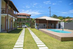uma casa com um quintal com uma piscina em Village Taipu de Fora em Maraú