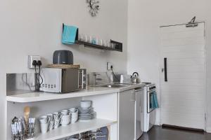 una pequeña cocina con fregadero y microondas en Maboneng Studio Loft, en Johannesburgo