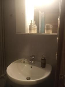W łazience znajduje się biała umywalka i lustro. w obiekcie On the METRO station of Korydallos w Pireusie