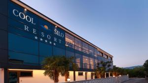 a building with a sign on the side of it at Cool Šilo Appartement Resort in Šilo