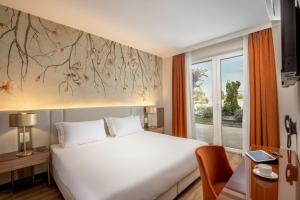 a bedroom with a large white bed and a window at Hotel Della Piana in Avezzano