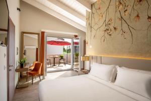 una camera da letto con un letto e un tavolo con un ombrello di Hotel Della Piana ad Avezzano