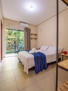 a bedroom with two beds and a large window at Village Brasil, Lençóis in Lençóis