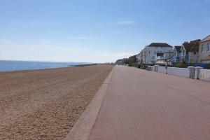 an empty beach with houses and the ocean at Beautiful house next to Beach & Park nr Zoo Newly refurbished in Kent