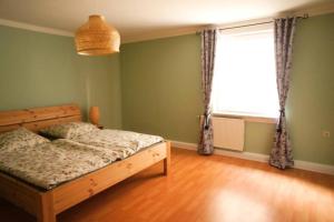 a bedroom with a bed and a large window at Gutshof Dobschütz - Urlaub auf dem Bauernhof in Nossen