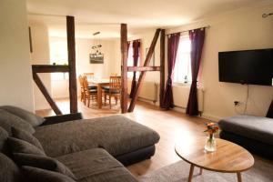 a living room with a couch and a table at Gutshof Dobschütz - Urlaub auf dem Bauernhof in Nossen