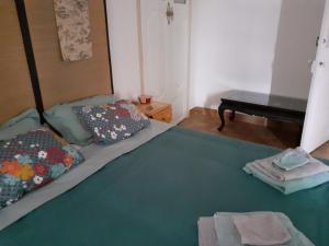ein Schlafzimmer mit einem Bett mit einer grünen Decke und einem Klavier in der Unterkunft SENTIMIR in Saint-Génis