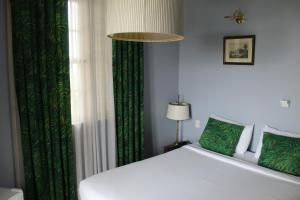 a bedroom with a white bed and a green curtain at L'Homme de Rio Boutique Hotel in Rio de Janeiro