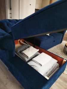een blauwe bank met een lade vol handdoeken bij Botanical garden apartment in Kaunas