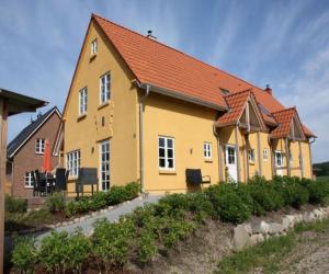 una casa amarilla con techo naranja en Ferienhaushälfte Nordlicht, en Krummin