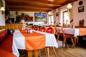 a restaurant with two tables and red chairs at Pension Sonnleit'n in Kirchdorf in Tirol