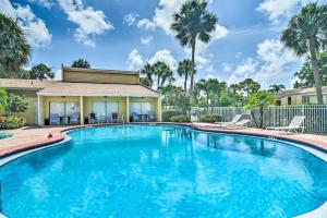 a swimming pool in front of a house with palm trees at Sarasota Escape about 4 Mi to Siesta Key Beach! in Sarasota