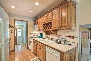 a kitchen with wooden cabinets and white appliances at Spacious Family Glenwood Estates Home with Hot Tub! in Glenwood