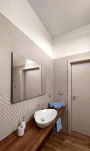 La salle de bains est pourvue d'un lavabo blanc et d'un miroir. dans l'établissement Casa Vacanze Le Volte, à Cellino San Marco