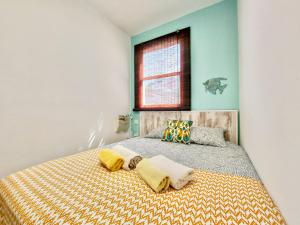 ein Schlafzimmer mit einem Bett mit gelben Kissen und einem Fenster in der Unterkunft Casa Ana con balcón in Punta del Hidalgo + 38 Fotos
