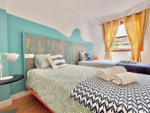 ein Schlafzimmer mit zwei Betten und einer blauen Wand in der Unterkunft Casa Ana con balcón in Punta del Hidalgo