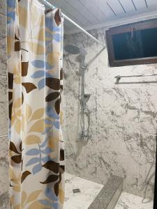a shower with a shower curtain in a bathroom at ORANGE INN in Chakvi +51 photos