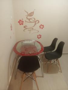 una mesa con 4 sillas y una taza de café en la pared en On the METRO station of Korydallos, en Pireo