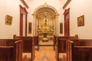 una iglesia con bancos de madera y un gran altar en Solar Do Conde en Capelas