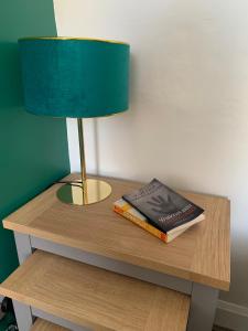 una lámpara y un libro sobre una mesa con una lámpara y una lámpara en Woodvale Flat, Renton, Loch Lomond, en Renton