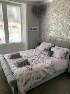 a bedroom with a large bed with pillows on it at Woodvale Flat, Renton, Loch Lomond in Renton
