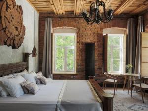 a bedroom with a large bed and two windows at Boutique-Hotel Truvor in Velikiy Novgorod