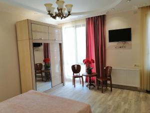a bedroom with a bed and a table with chairs at ORANGE INN in Chakvi