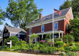 a red brick house with an american flag on it at The Water Street Inn in Kittery