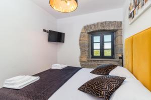 sypialnia z łóżkiem z telewizorem i oknem w obiekcie Villa Grazia - with heated salt water Pool w mieście Pazin +37 zdjęć