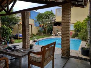een patio met een tafel en een zwembad bij Flor de Jagube in Ubatuba