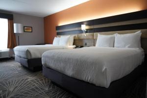 a hotel room with two beds with white pillows at La Quinta by Wyndham Branson in Branson