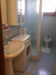 uma casa de banho com uma máquina de lavar roupa e um lavatório em Casa Mary venezia lido em Lido di Venezia