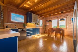 una cocina con armarios azules y una mesa con sillas en Finland House Barcelona- Ideal familias en Argentona