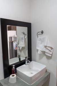a bathroom with a white sink and a mirror at Departamento La Choza Central Pool in GDL downtown in Guadalajara