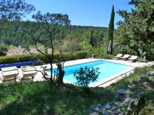 a swimming pool in a yard with chairs around it at Charm in Provence in Saumane-de-Vaucluse