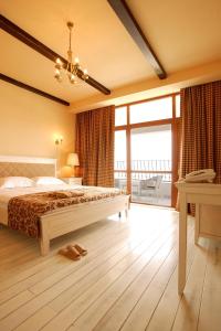 a bedroom with a bed and a large window at Arcadia Hotel - Marina Regia Residence in Mamaia Sat/Năvodari