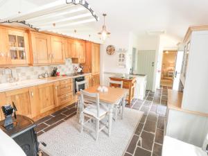 uma cozinha com armários de madeira e uma mesa com cadeiras em Lakeside Cottage em Boyle