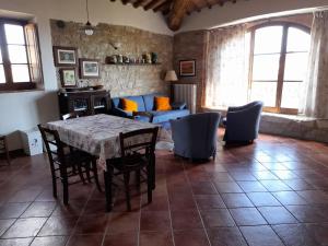 a living room with a table and chairs and a couch at Borgo Beccanella in Asciano