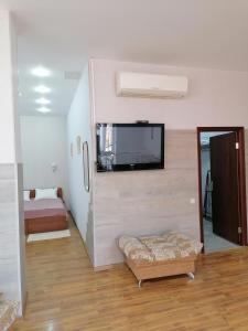 sala de estar con TV de pantalla plana en la pared en Sunny Harbour, en Novorossiysk