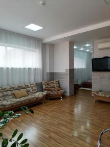 una gran sala de estar con sofás y TV de pantalla plana. en Sunny Harbour, en Novorossiysk