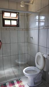 Un baño blanco con inodoro y ventana. en Chalé & Suítes Mar Aberto, en Ilhabela 31 fotos más