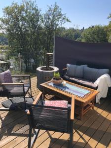 a patio with a couch and a table and chairs at Aid og Svein’ s sentrumsnære panorama hjem in Kristiansand